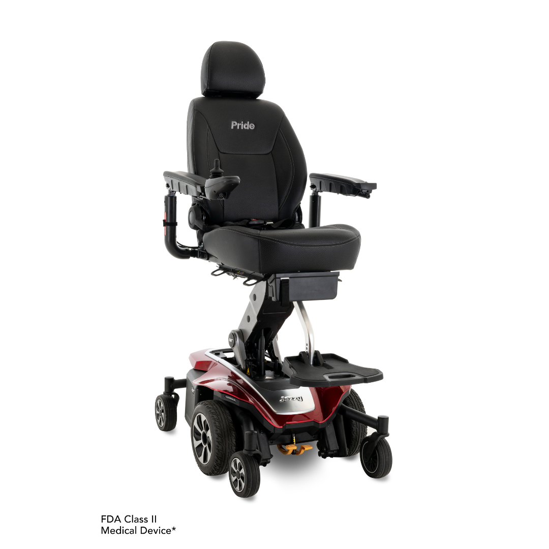 A stylish red Pride Mobility Jazzy Air® 2 powerchair, offering a padded black seat with adjustable armrests and vertical seat elevation. Supported by four sturdy wheels, it features the FDA Class II Medical Device label in the lower left corner to emphasize its mobility capabilities.